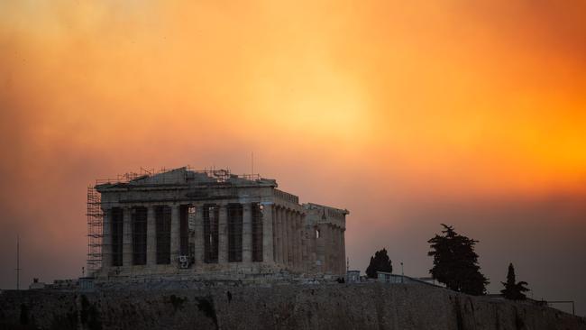 The Parthenon temple atop the Acropolis hill shrouded in a smoke cloud. (Photo by Angelos TZORTZINIS / AFP)