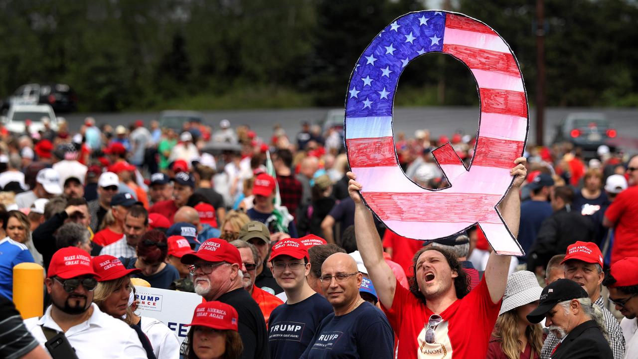 David Reinert holds up a large "Q" sign while awaiting the arrival of US President Donald Trump at a "Make America Great Again" rally. Picture: AFP