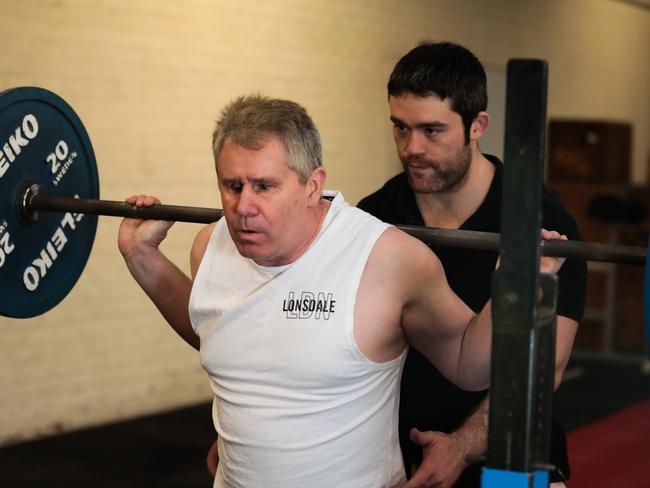 Phil Menzie (above), who is visually impaired and attends the Raw Strength gym with his labrador Yoda, gets a lot out of training with Matthew McKay. Picture: Mireille Merlet