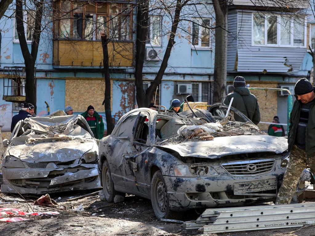 A man walks past damaged cars after Russian forces attacked a residential building. Picture: AFP