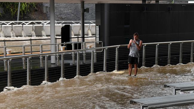 A man doesn’t mind getting soaked to take a snap of the record-breaking rain. Picture: Bianca De Marchi