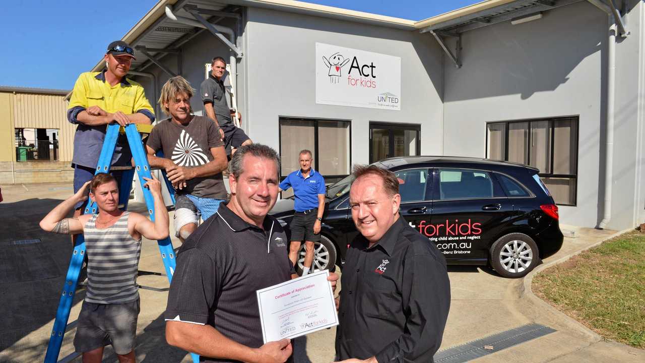 In Gympie in happier times are Gene Farrelly - Director with United receiving a Certificate of Appreciation from Dr Neil Carrington, the CEO of Act for Kids with some of the tradesman who worked on the project. Picture: Greg Miller