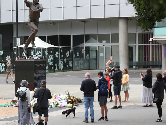 People lay flowers at the statue of Shane Warne at the Melbourne Cricket Ground. Picture: NCA NewsWire / David Crosling