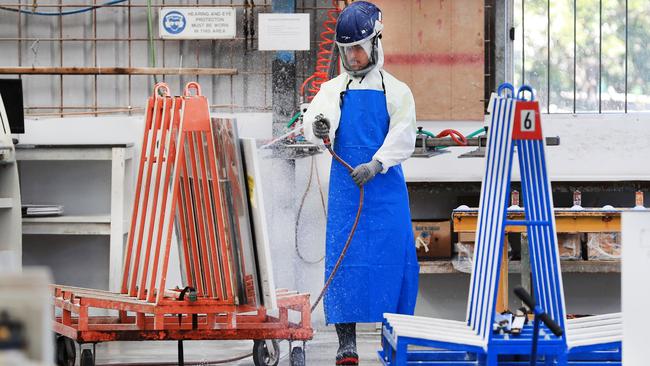 Stone benchtop workers at La Rocca Marble and Granite in Arundel are fully protected from silica dust. Photo: Scott Powick