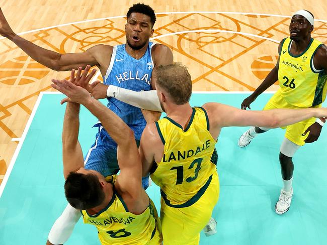 LILLE, FRANCE - AUGUST 02: (EDITORS NOTE: Image was captured using a remote camera positioned above the field of play) Giannis Antetokounmpo #34 of Team Greece shoots against Matthew Dellavedova #8 of Team Australia and Jock Landale #13 of Team Australia during the Men's Group Phase - Group A match between Team Australia and Team Greece on day seven of the Olympic Games Paris 2024 at Stade Pierre Mauroy on August 02, 2024 in Lille, France. (Photo by BASKETBALL GLASS SHAMUS/Getty Images)