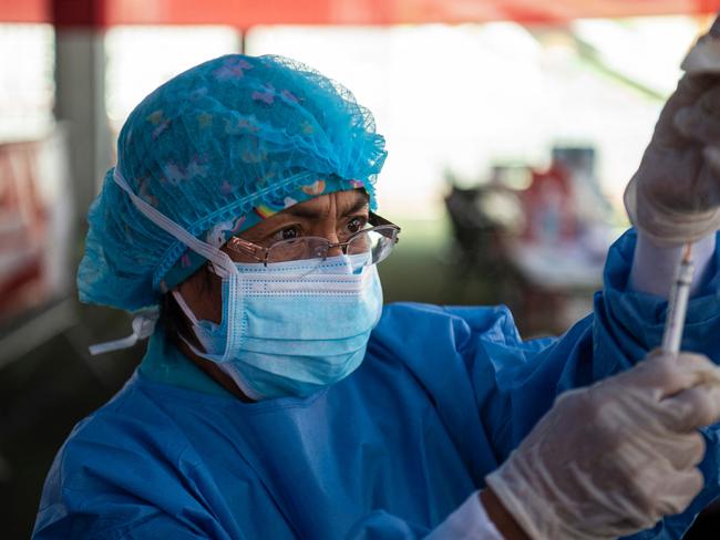 A health worker prepares to inoculate a child with a dose of the Covid vaccine. Picture: AFP