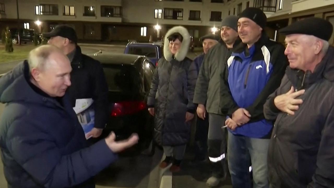 Russia's President Vladimir Putin (L) speaking with supposed apartment block residents as he visits the Ukrainian city of Mariupol. Picture: AFP