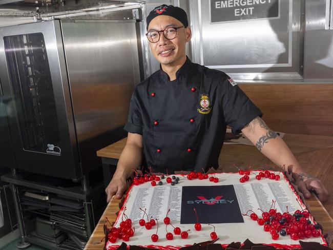 Able Seaman chef Huong Long holds the ceremonial cake for the ship’s welcoming ceremony. Picture: Supplied