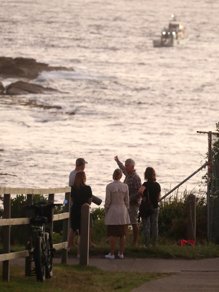 Onlookers as search boats return to the water at Little Bay. Picture: John Grainger