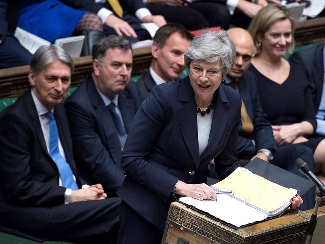 A handout photograph taken and released by the UK Parliament on March 27, 2019 shows Britain's Prime Minister Theresa May speaking during the weekly Prime Minister's Questions (PMQs) question and answer session in the House of Commons in London. - Prime Minister Theresa May on Wednesday pledged to step down if MPs back her EU divorce deal, in a bid to break the Brexit deadlock in Britain's fractured parliament. Her dramatic gambit came just two hours before MPs started a flurry of votes seeking a last-minute alternative Brexit plan to replace her deal. (Photo by JESSICA TAYLOR / various sources / AFP) / EDITORS NOTE THE IMAGE HAS BEEN DIGITALLY ALTERED AT SOURCE TO OBSCURE VISIBLE DOCUMENTS  - RESTRICTED TO EDITORIAL USE - NO USE FOR ENTERTAINMENT, SATIRICAL, ADVERTISING PURPOSES - MANDATORY CREDIT " AFP PHOTO /JESSICA TAYLOR/ UK Parliament"