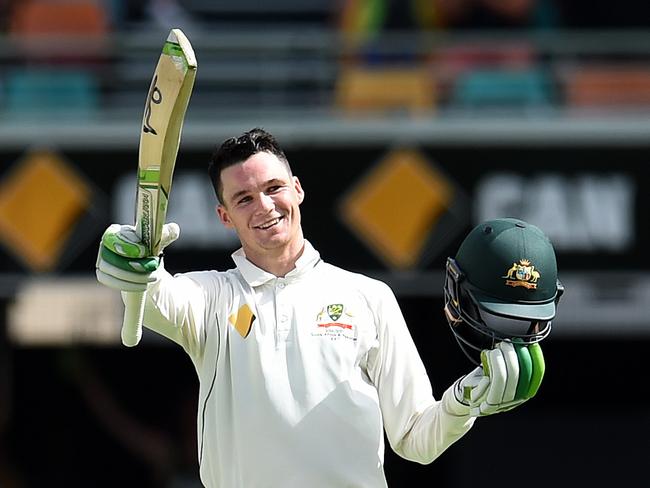 Handscomb salutes after notching his maiden Test ton at the Gabba.