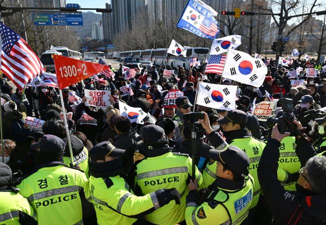 People gather inside the barricade blocking the road leading to the residence of impeached South Korean President Yoon Suk Yeol