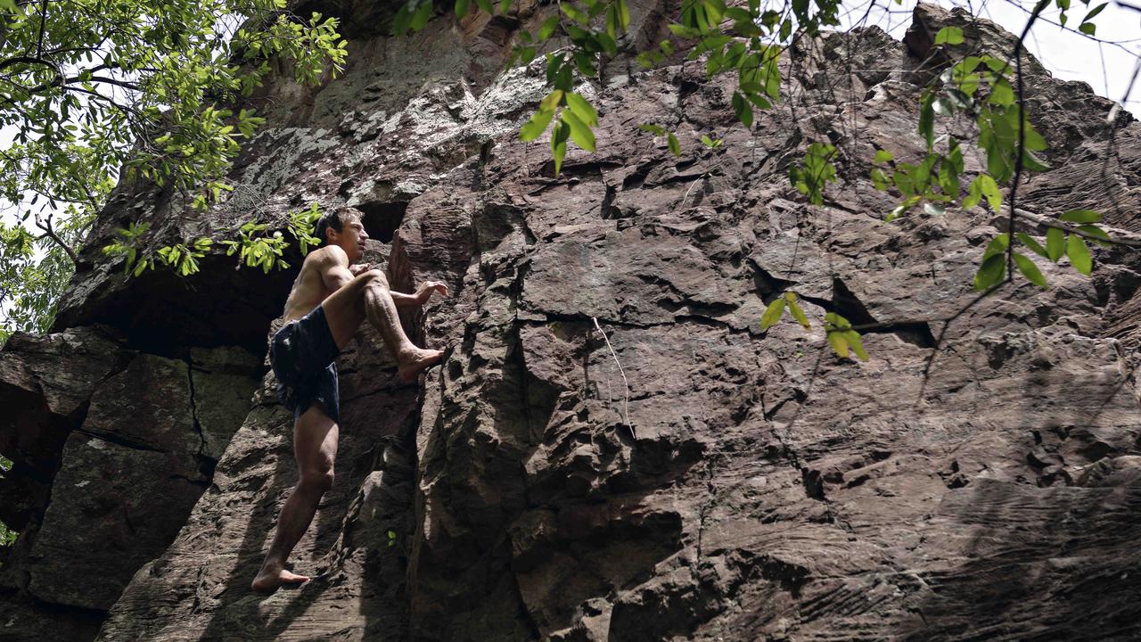 Adelaide Crows coach Matthew Clarke scales the cliffs at Florence Fall in Litchfield National Park when the AFLW team spent the day there after playing Fremantle in a trial match at TIO Stadium in Northern Territory.