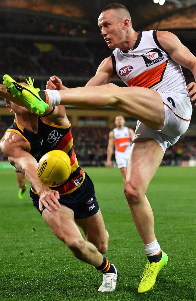 Tom Scully of the Giants kick is smothered by Brad Crouch of the Crows.