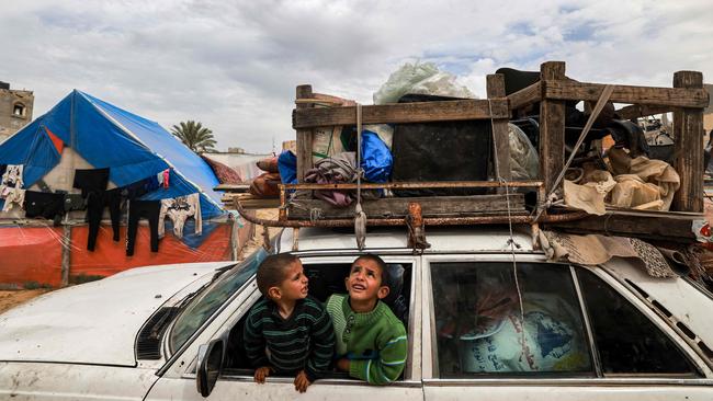 Children sit inside a vehicle loaded with items secured by rope as people flee from Rafah. Picture: Mohammed Abed/AFP