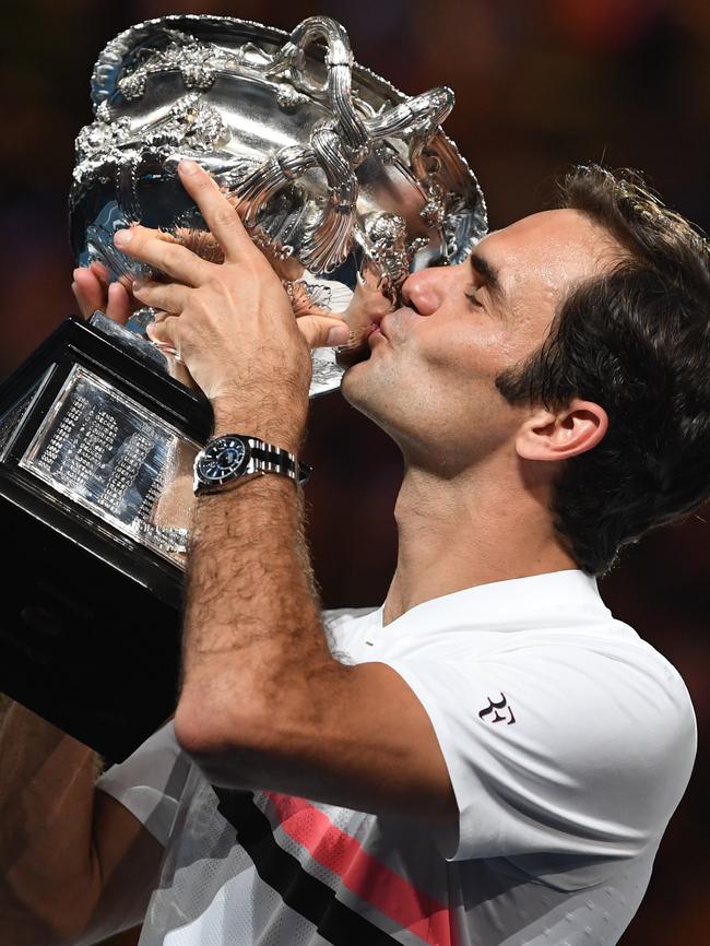 Roger Federer kisses his newest Australian Open trophy.