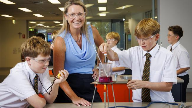 Science teacher Amy Ayres in class with Year 7 students Alfie Gough and Fox Moss at St Augustine's College in Brookvale on Sydney's northern beaches. Picture: Toby Zerna.