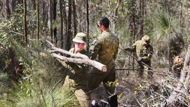 Defence force personnel working to clear maintenance tracks for firefighters in the Lower Beechmont area. Picture: Glenn Hampson