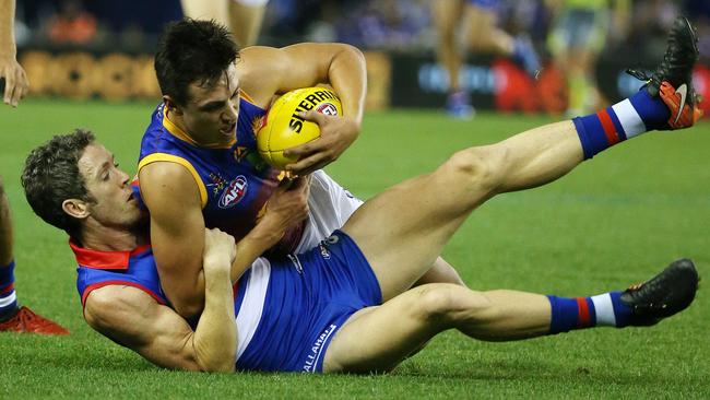 Hugh McCluggage is tackled by Bob Murphy. Picture: George Salpigtidis