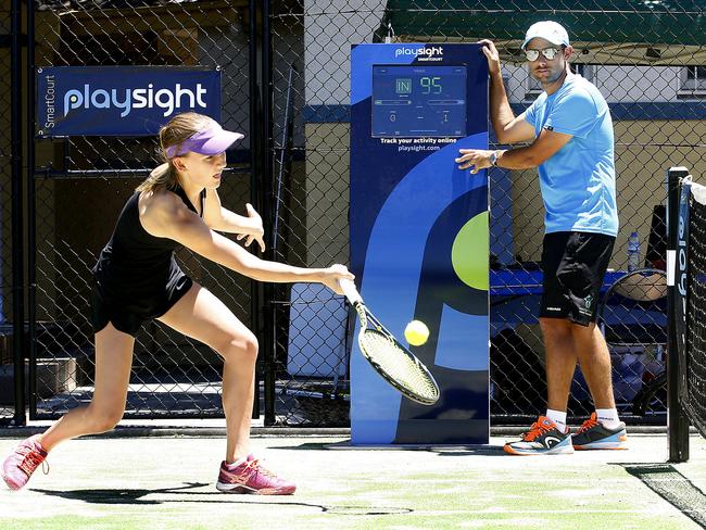 Delphi Hinchcliffe, 13, tries out the PlaySight smart tennis court at Centennial Parklands Sports centre under the guidance of coach Adrian Montgomery. Picture: John Appleyard