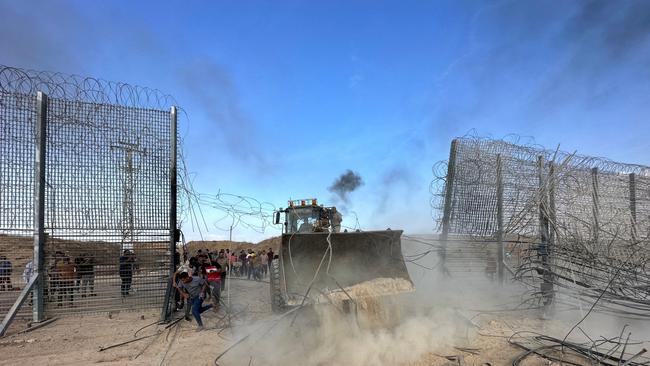 Palestinians break into the Israeli side of Israel-Gaza border fence. Picture: Reuters