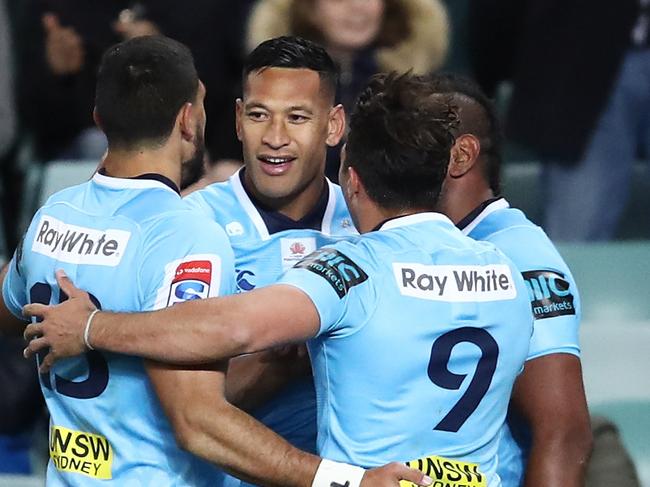 Israel Folau celebrates a try with teammates.