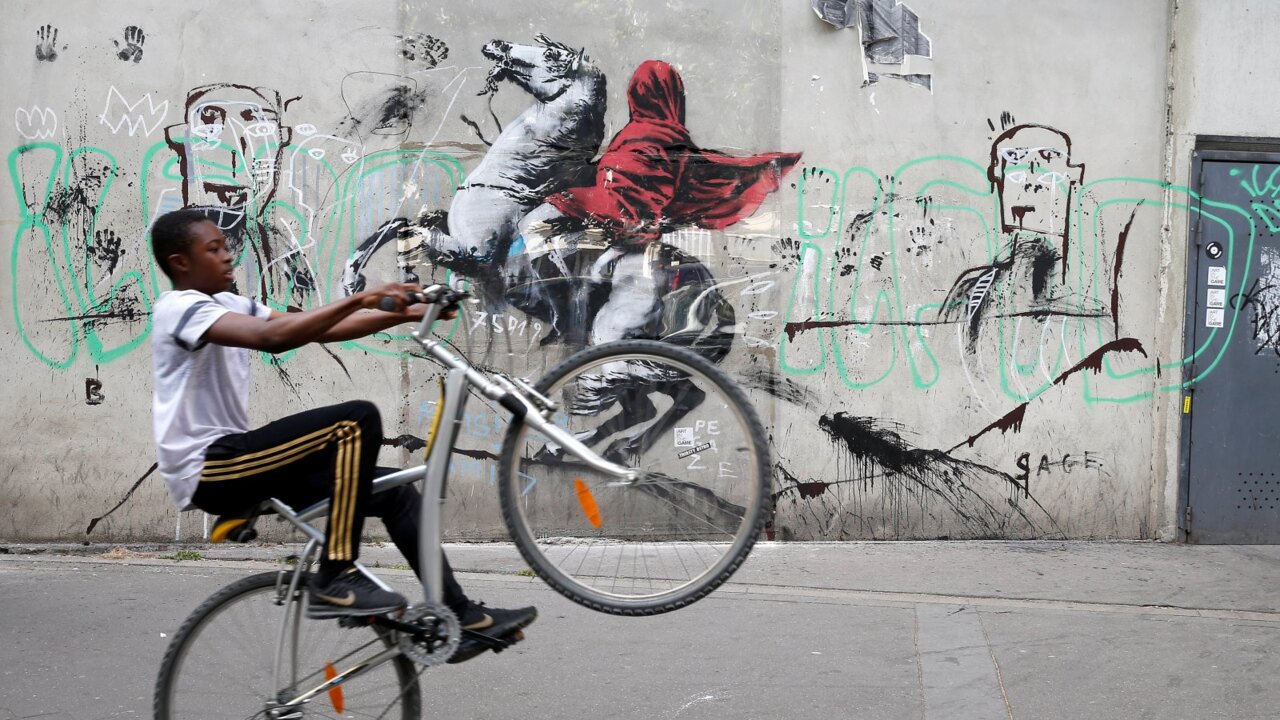 Street artist Banksy takes aim at migrant crisis, greed as he hits Paris  for first time