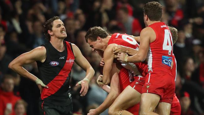 Dejected Bomber Joe Daniher can only lament what might have been as the Swans celebrate victory. Picture. Phil Hillyard