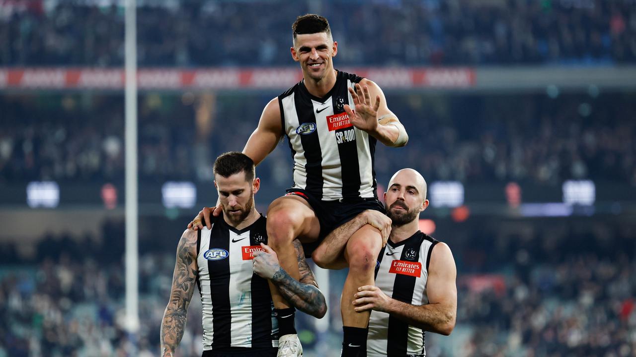 MELBOURNE, AUSTRALIA - AUG 03: Scott Pendlebury of the Magpies is chaired off the ground by teammates Jeremy Howe (L) and Steele Sidebottom (R) after his 400th game during the 2024 AFL Round 21 match between the Collingwood Magpies and the Carlton Blues at The Melbourne Cricket Ground on August 03, 2024 in Melbourne, Australia. (Photo by Dylan Burns/AFL Photos via Getty Images)