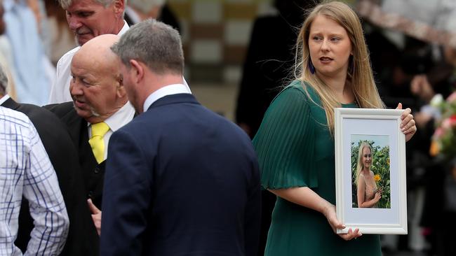 Michaela sister holds a framed photo. Picture: Toby Zerna