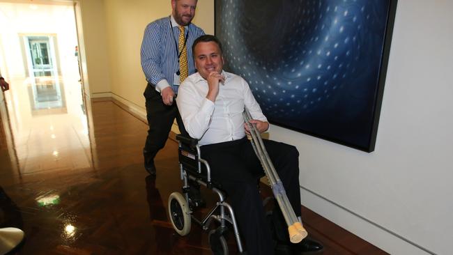 Jamie Briggs in a wheelchair arriving party room meeting at Parliament House in Canberra. Picture: Kym Smith