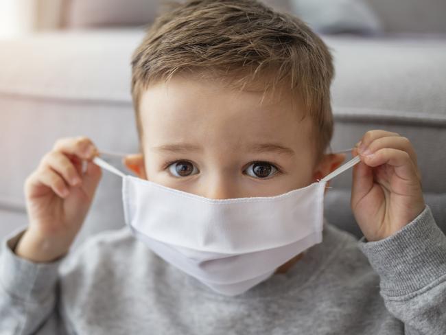 Young child wearing a respiratory mask as a prevention against the Coronavirus Covid-19. Little boy wearing anti virus mask staying at home. Protection against flu and virus infection