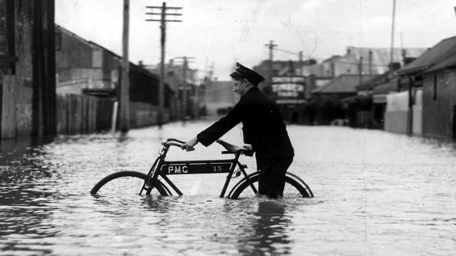 Transport stopped in December 1934 as Melbourne streets are turned into canals but the postman was determined to get telegrams through.