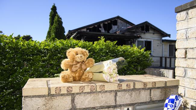 Neighbours leave flowers and a teddy following a fatal house fire in Harristown, Thursday. Picture: Kevin Farmer
