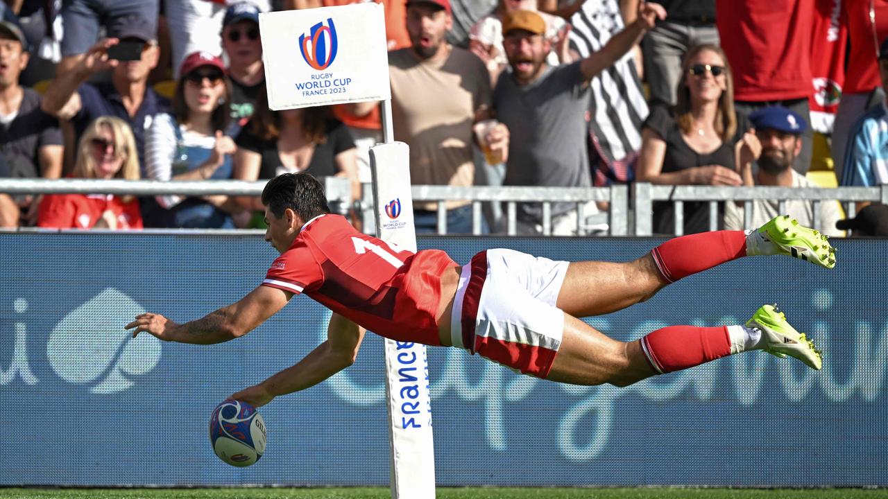 Wales’ wing Louis Rees-Zammit dives across the line to score a try. (Photo by LOIC VENANCE / AFP)