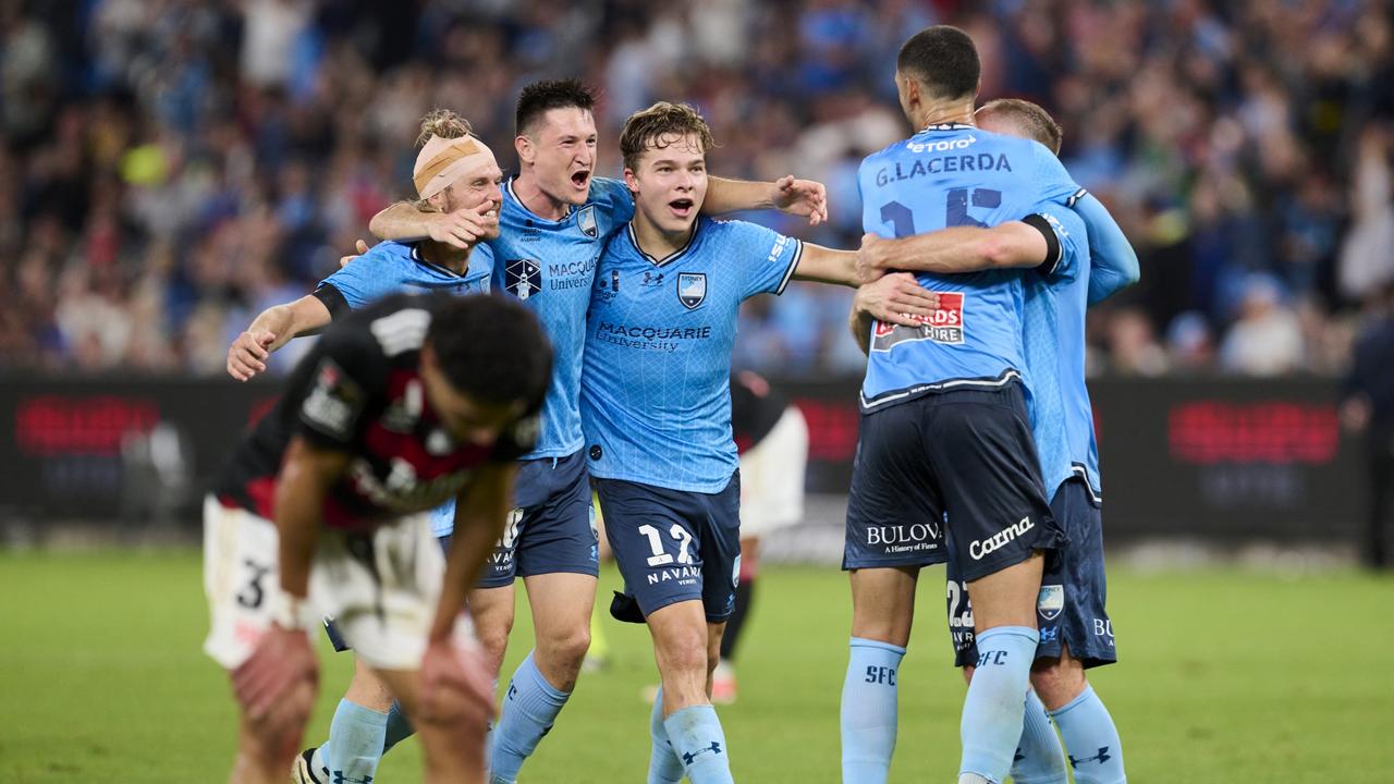 Sydney FC players celebrate their winning goal as the shattered Wanderers contemplate defeat. Picture: Brett Hemmings/Getty Images