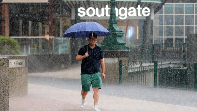 A man tries to stay dry during the storm. Picture: Mark Stewart