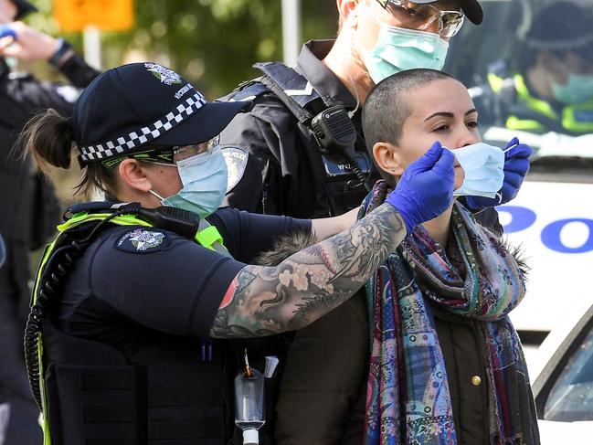 Police place a face mask on an arrested protester during an anti-lockdown rally at Melbourne’s Shrine of Remembrance in September last year. Picture: AFP