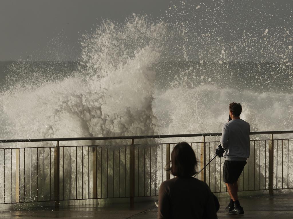 People watch the huge surf pound Bronte pool. Picture: John Grainger