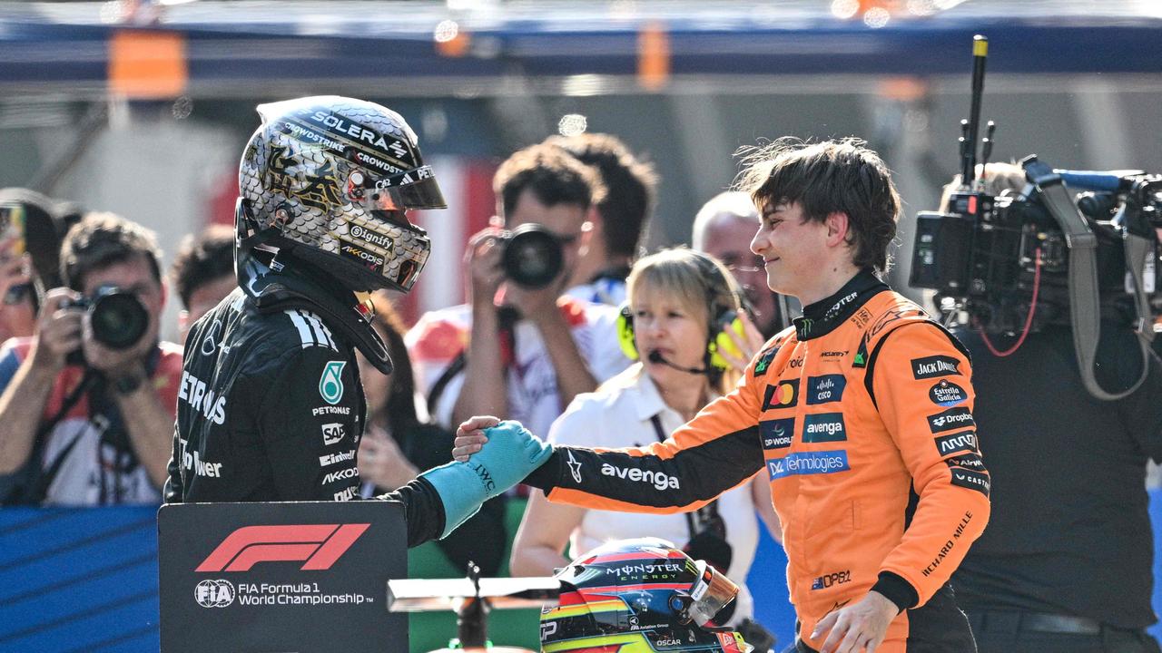 McLaren's Australian driver Oscar Piastri (right) shakes hands with George Russell after taking pole. (Photo by Hector RETAMAL / AFP)