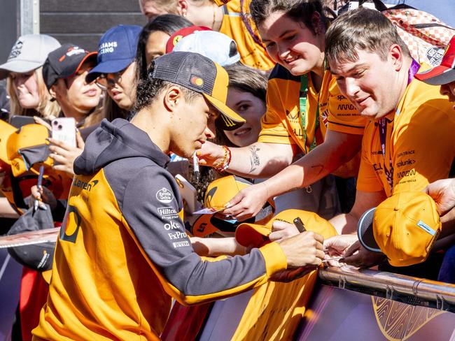 Lando Norris, pictured greeting fans upon arrival at Albert Park, has his eyes on the world championship. Picture: Jake Nowakowski