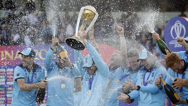 England's captain Eoin Morgan is doused in champagne as he raises the trophy after winning the Cricket World Cup final match between England and New Zealand at Lord's cricket ground in London, Sunday, July 14, 2019. England won after a super over after the scores ended tied after 50 overs each. (AP Photo/Matt Dunham)