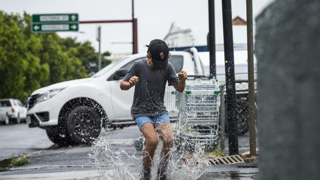 Blake Obst jumps in a puddle near Victoria St as steady rain falls across Toowoomba on Saturday. Picture: Kevin Farmer