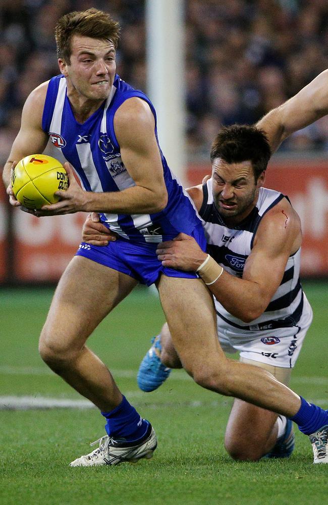 Kangaroo Luke McDonald breaks away from Cats champion Jimmy Bartel. Picture: Colleen Petch