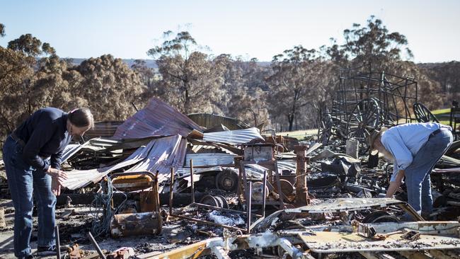 WAIREWA, AUSTRALIA - JANUARY 12: Brian and Elizabeth Blakeman inspect the bushfire damage to their property  on January 12, 2020 in Wairewa, Australia. Brian and Elizabeth Blakeman remained at their home atop the hill to battle the fire after it encircled the property on the 30th December. Three CFA trucks came to the property to use the high vantage point so firefighters could determine where the fire was coming from and told them that the house couldn't be saved and that they should leave. Brian and Elizabeth used hoses and sprinklers to save the house but the outlying buildings and orchard were destroyed. The large shed contained a caravan, boat, tractor and two stage coaches built by Brian and used to take holidays through the high country. A keen saddler, all Brian's saddles and saddlery equipment were ravaged. They are not sure why their house was spared whilst half of the tiny hamlets 22 homes were destroyed. The Blakemans say they are now feeling a bit of "battle fatigue" from the constant threat the region is facing and are feeling overwhelmed about where to start when it comes to assessing the damage and related insurance claims. Fires in New South Wales, Victoria, Queensland, Western Australia and South Australia have burned more than 10 million hectares of land in recent months. 21 people have been killed, including three volunteer firefighters in NSW and a firefighter in Victoria, and thousands of homes and buildings have been destroyed. (Photo by Chris Hopkins/Getty Images)