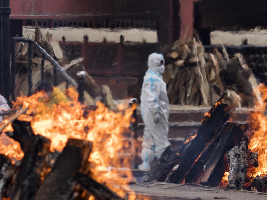 A man wearing protective equipment performs the last rites to his relative who died of COVID-19 at a crematorium in New Delhi. Picture: Anindito Mukherjee/Getty Images