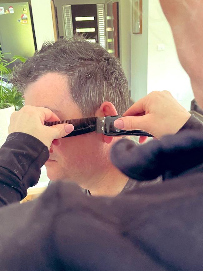 Daniel Andrews gets a home hair cut from wife Catherine. Picture: Twitter/@CathLAndrews