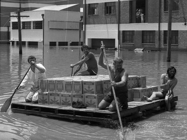 Beer being paddled to safety during the Brisbane floods. The Courier-Mail Photo Archive. 31/1/1974