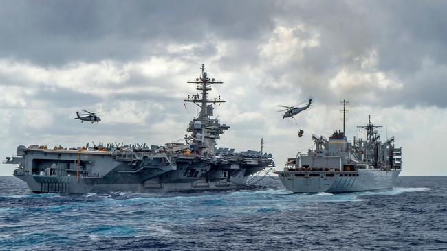 The US Navy’s Nimitz-class aircraft carrier Abraham Lincoln conducts a replenishment-at-sea with the fast combat support ship Arctic. An overstretched and distracted Washington is being pushed by allies and tested by adversaries. Picture: MCSN Jason Waite / US Navy Office of Information / AFP