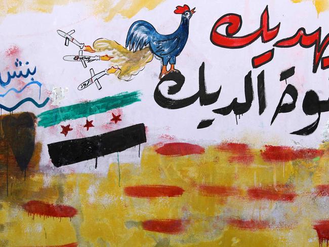 Graffiti in the rebel-held Syrian town of Binnish compares the President’s strike to ‘a rooster’s fart.’ Picture: AFP Photo/Omar Haj Kadour